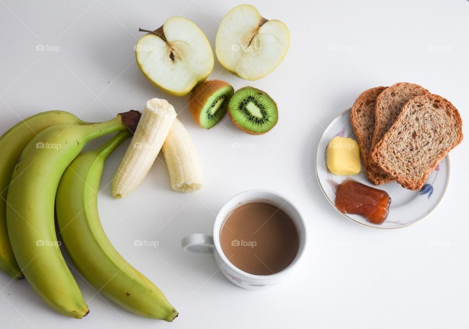 The healthy breakfast with fruit, coffee and toast with butter and jam. 
