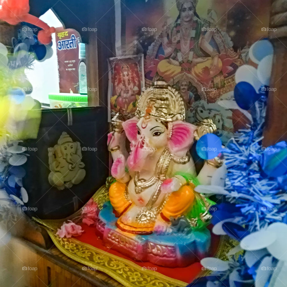 Indian festival, Indian God idol, colorful statue of God in the decorated room, worshipping place in the house
