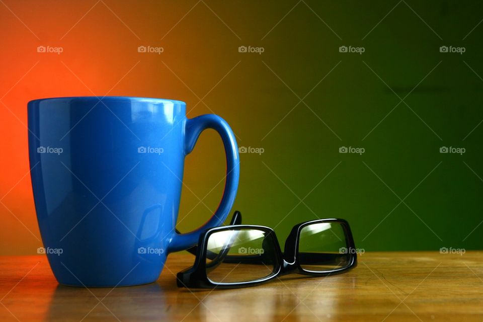 blue coffee mug and eyeglasses