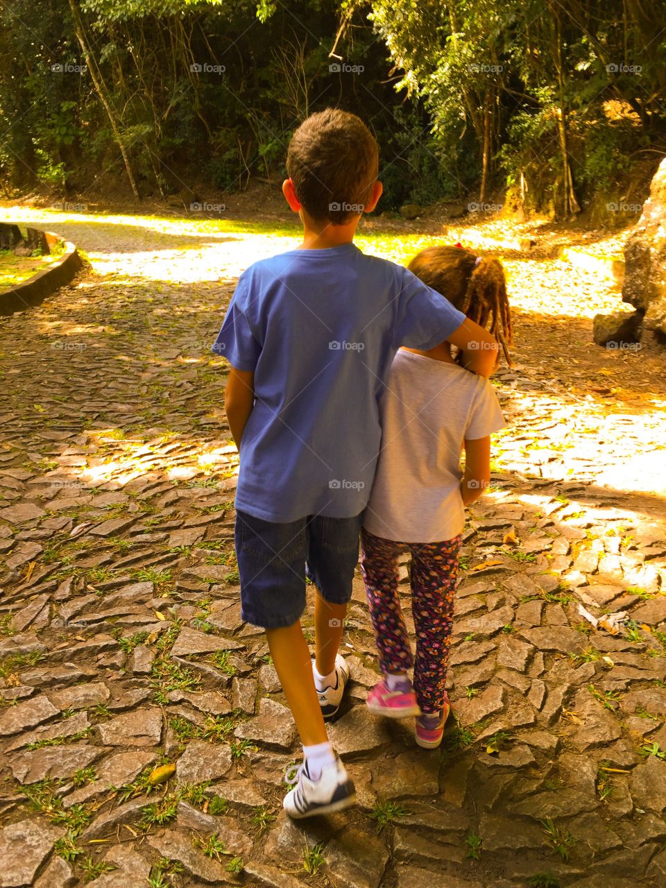 Brother and sister walking in the park