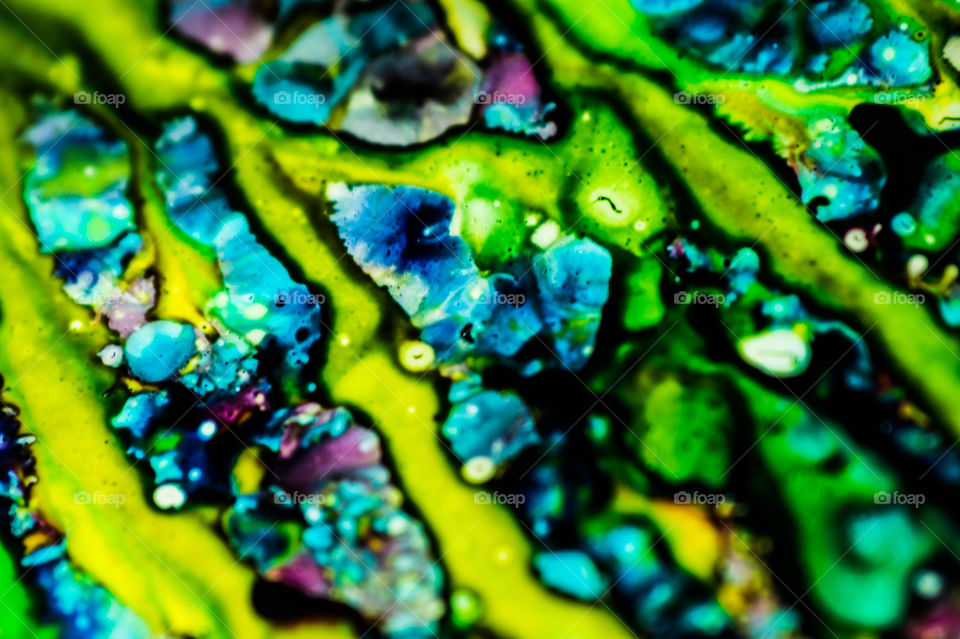 The ink to refill the printer cartridge was spilled onto the white washbasin and the paints blended into abstract drips and patterns