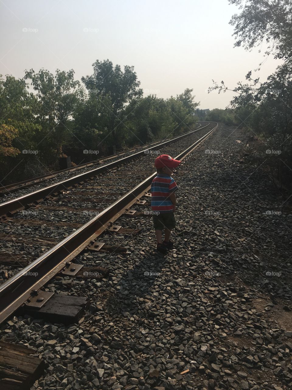Toddler checking out railroad tracks