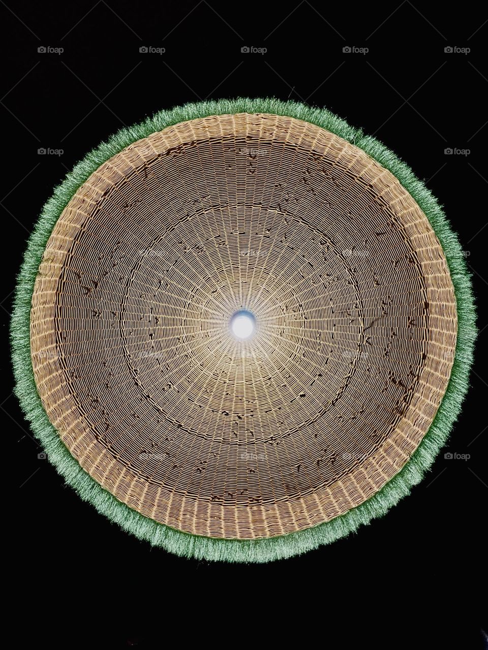 Beneath a rattan lampshade 