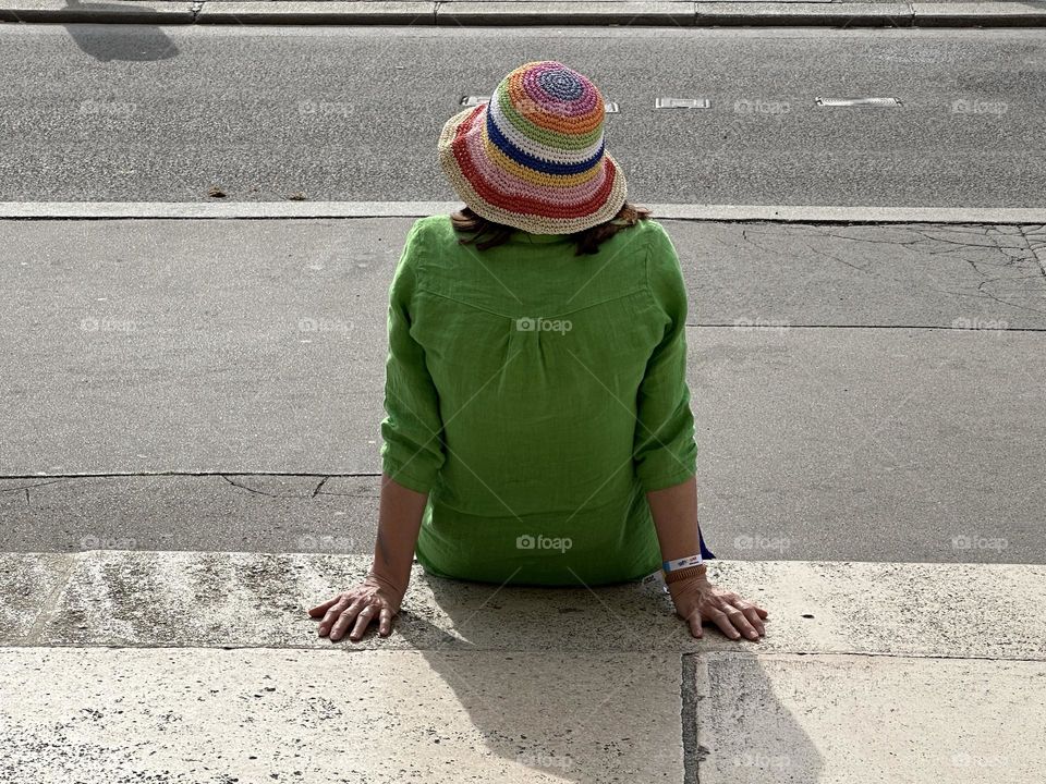 A woman in a rainbow color stripe sun hat