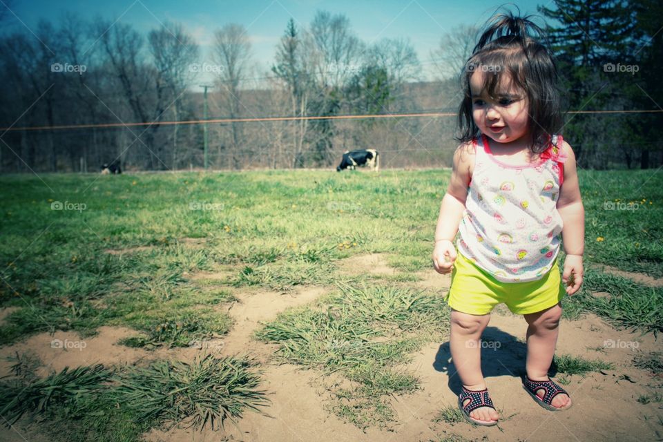 Cute baby girl standing in filed