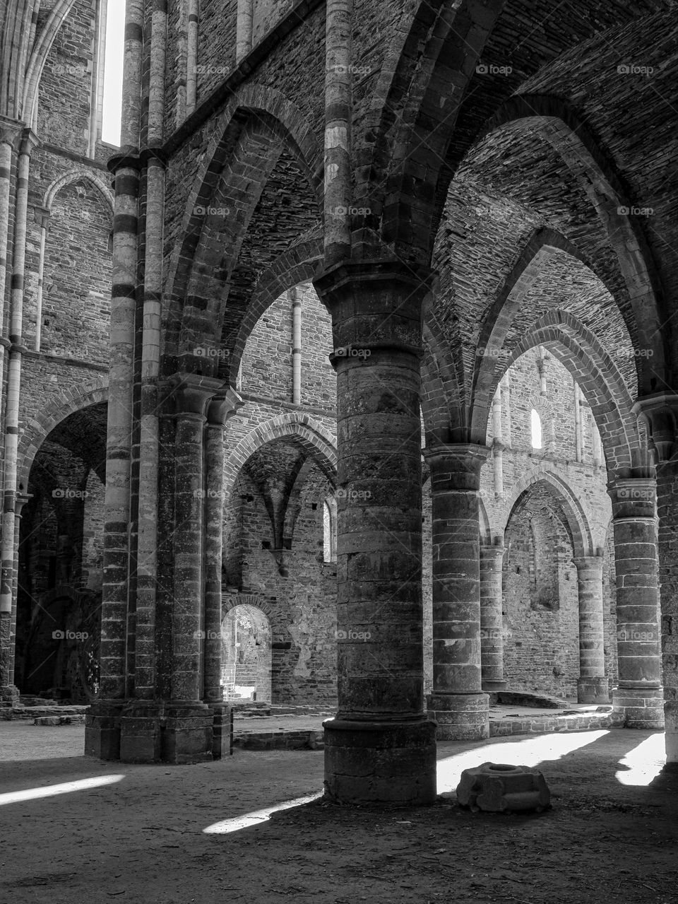 Beautiful view of the historical ancient columns and arches of the ruined monastery of Villers la Ville in belgium, close-up side view. The concept of the architecture of ancient castles.