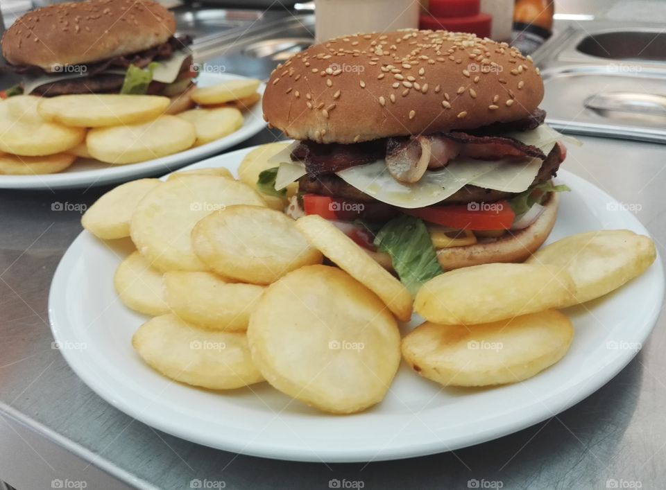 two bacon burger on plate with french fries closeup