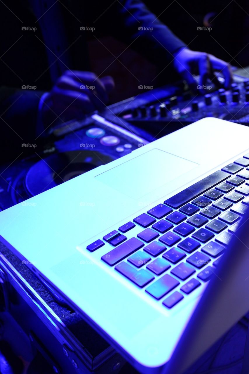 DeeJay playing music on his mixing DJ station console