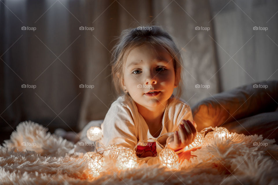 Little sisters reading a book at Christmas time 