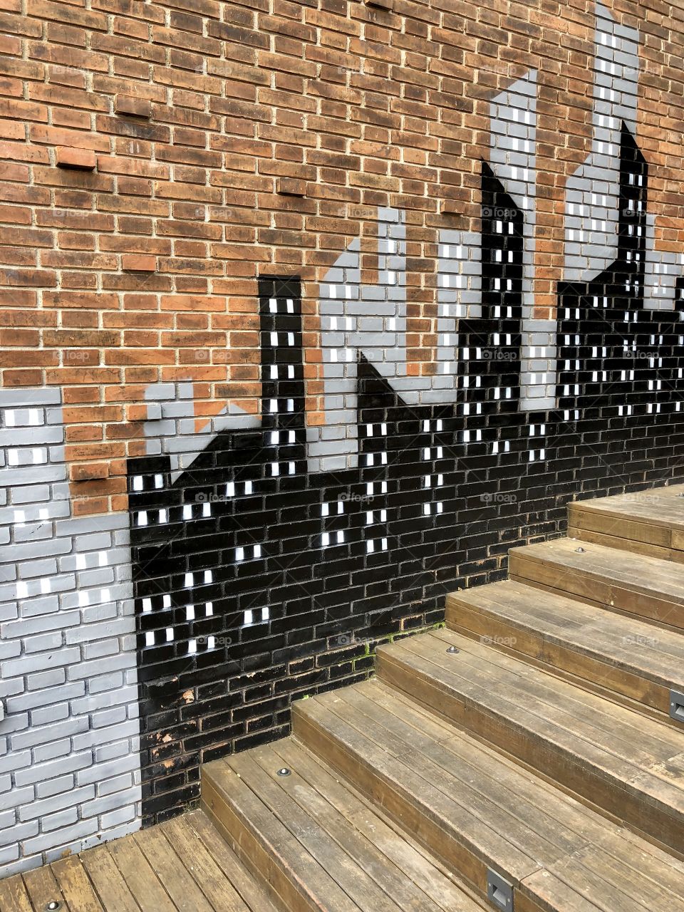 Red brick wall cityscape mural 2. Wood steps. Taken August 2018.