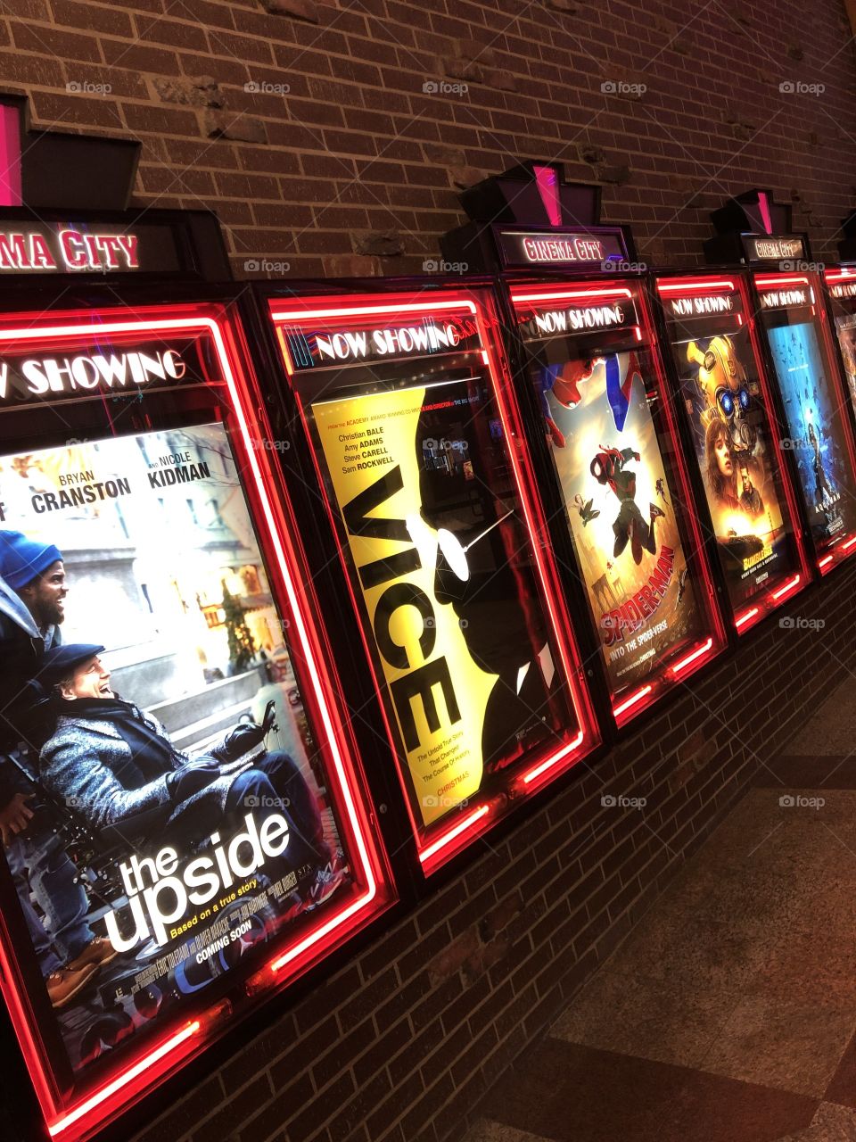 Now showing neon lights posters lineup of movies at theaters in United States 