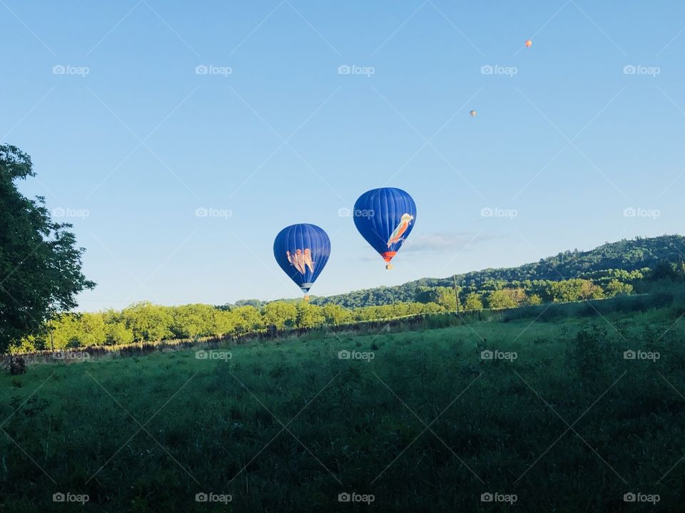 Blue balloons in the pale blue sky in France