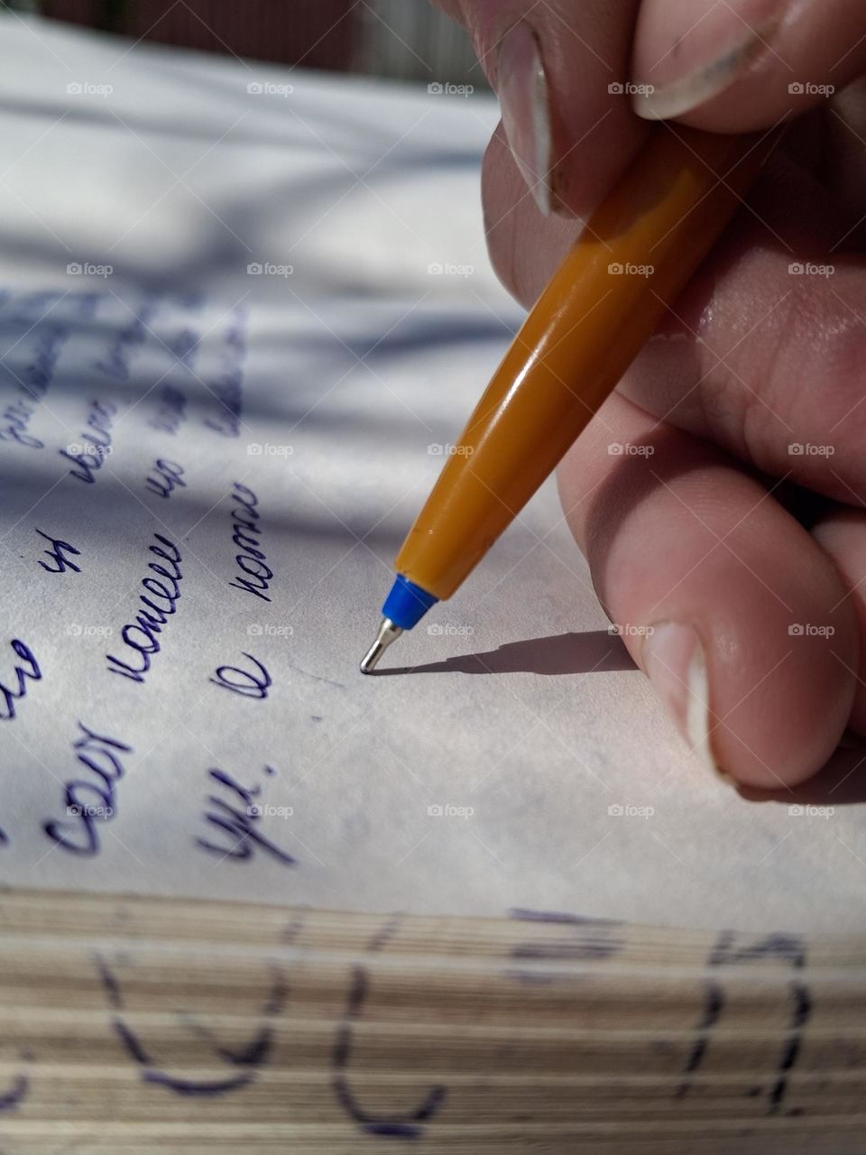 Artistic macro photo showing the vivid complementary colors of blue and orange through a detailed view of handwriting with a ballpoint pen
