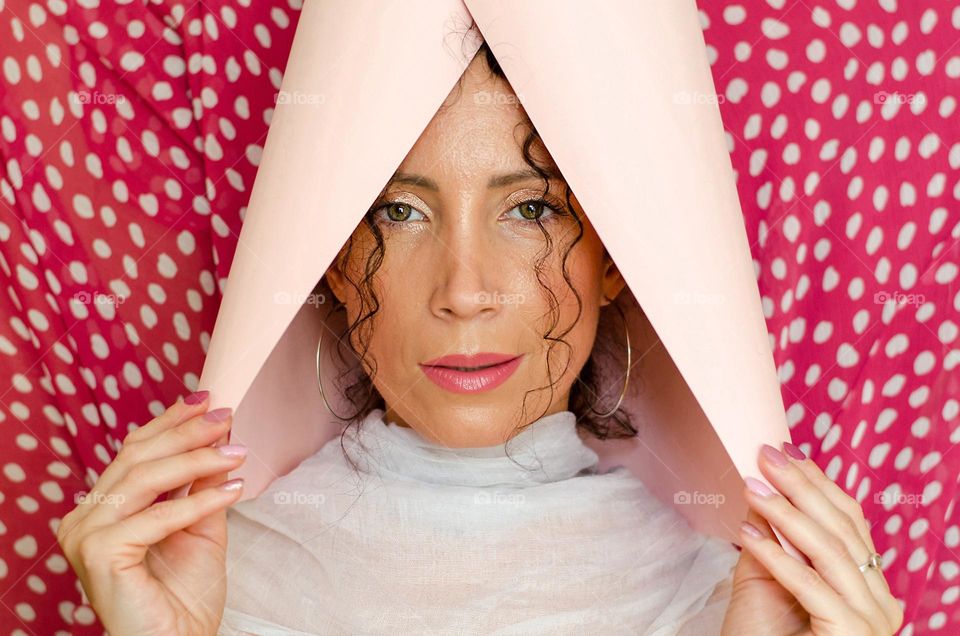 Portrait of a woman brunette on pink background