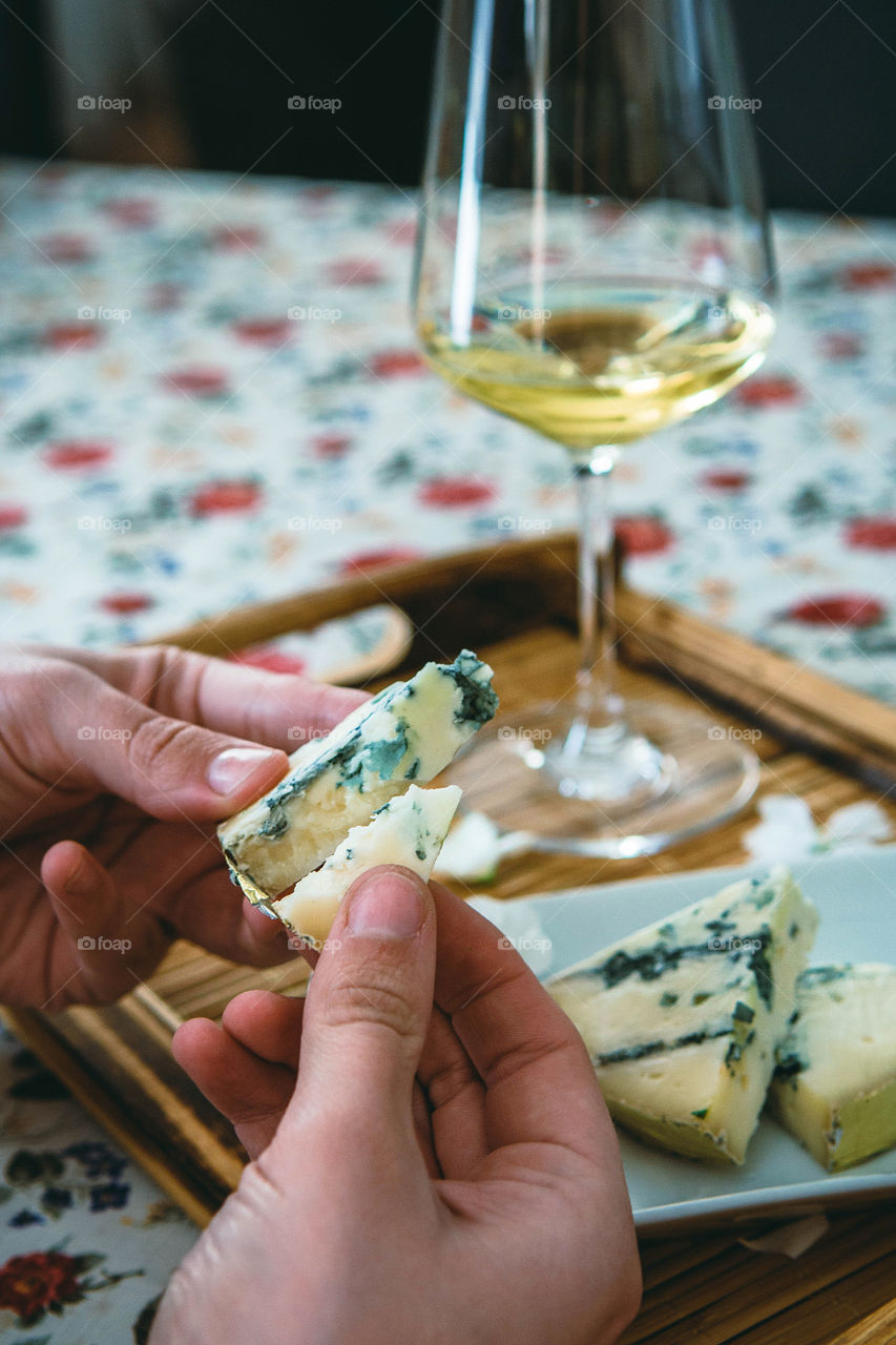 Person holding cheese with beer