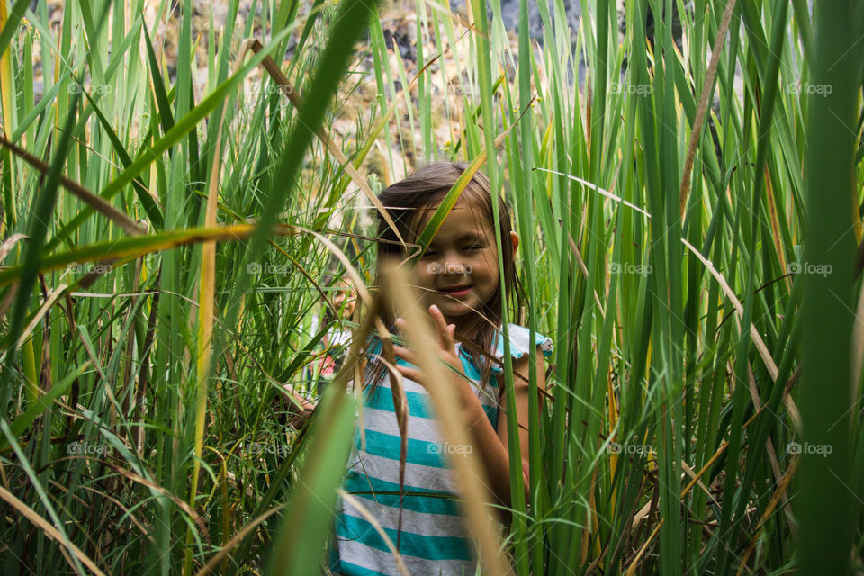 Portrait of a girl standing in green tall grass