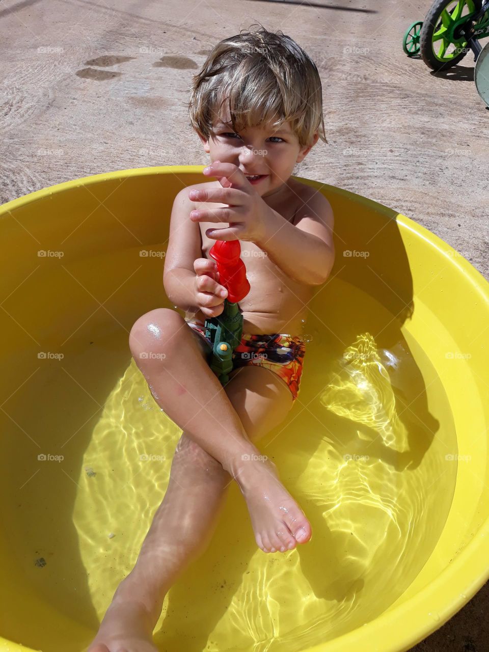 child playing in yellow basin