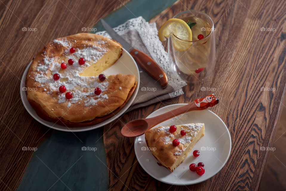 Cheesecake with cranberries and sugar on wooden background