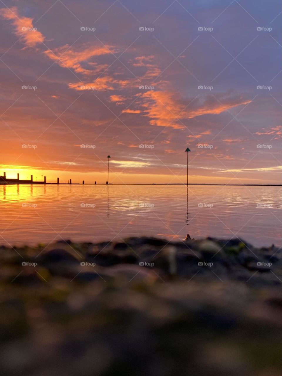 A warm beach sunrise photo with water reflections 