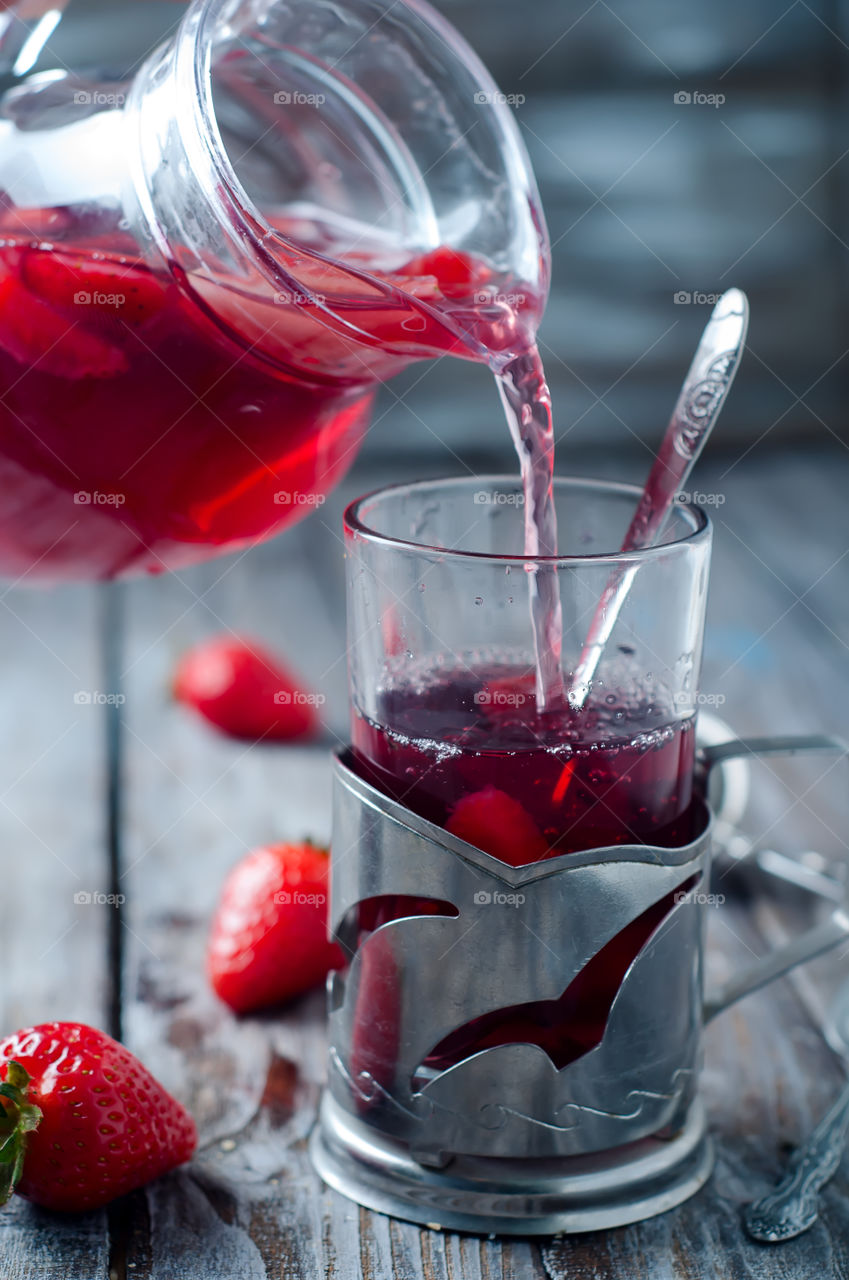 Pouring strawberry juice in glass