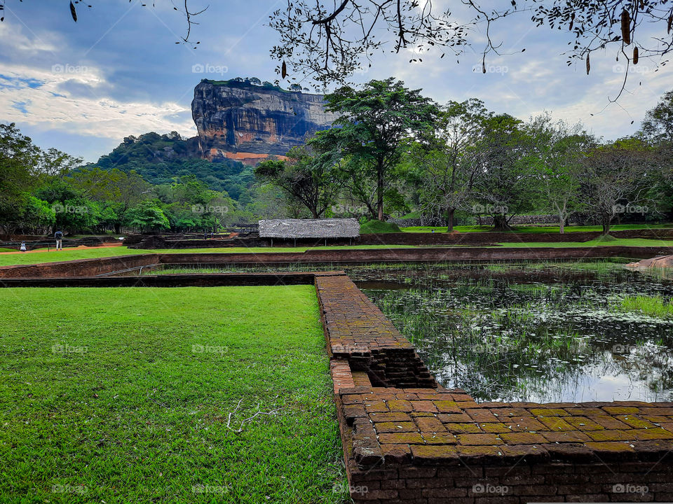 Scenic water gardens of Sigiriya. Built between 477 to 495 AD, Sigiriya is a rock fortress along with a scenic and complex city. This is a view of Sigiriya from its beautiful water gardens.