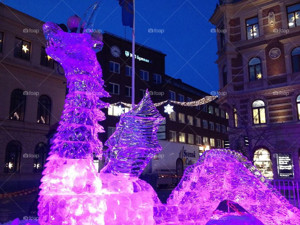 A beautiful ice sculpture of a dragon in a magical light.