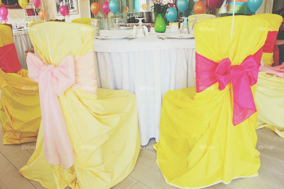 Yellow decoration. Yellow chairs with ribbon