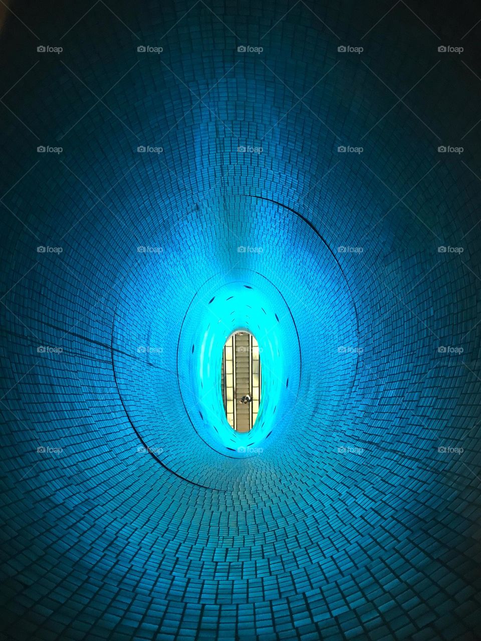 Oval window, looking down at the escalator at Toledo subway station, Naples, Italy