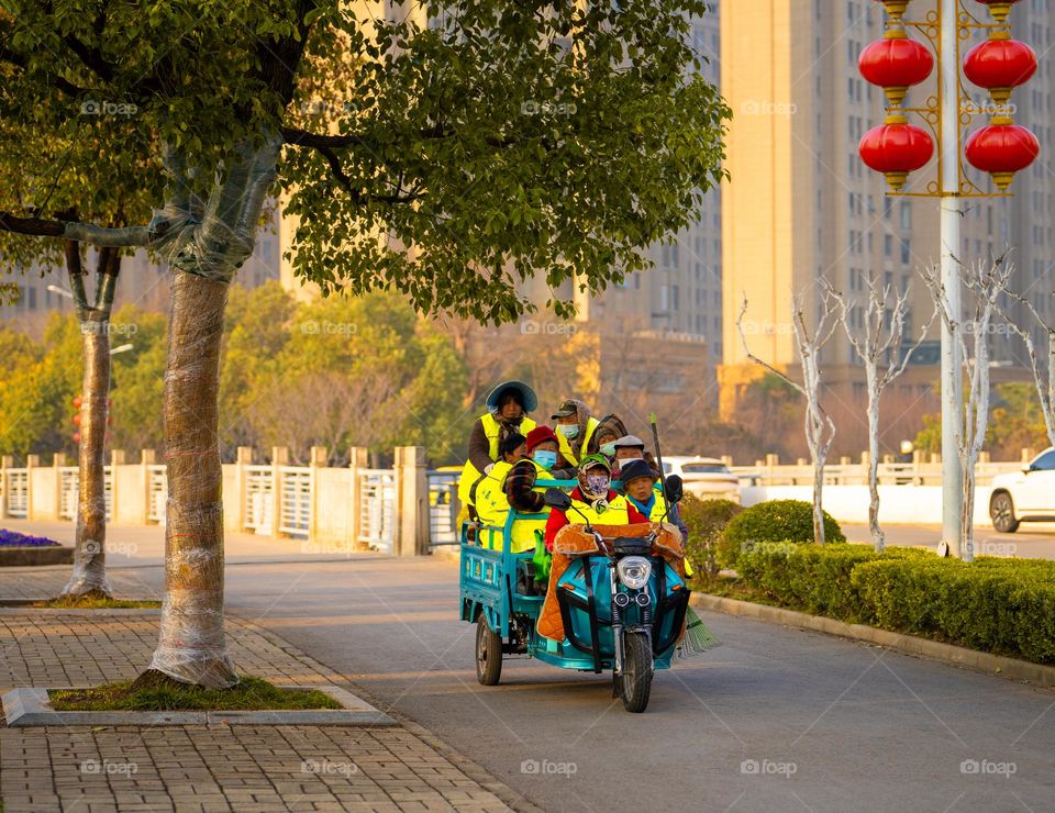 A group of people on tricycle car.