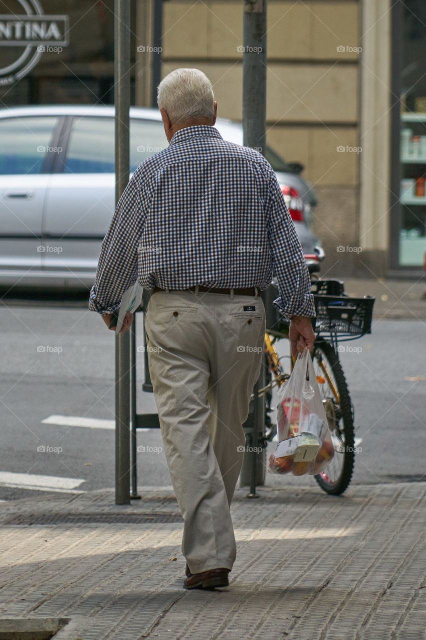 Elderly man coming back from shopping