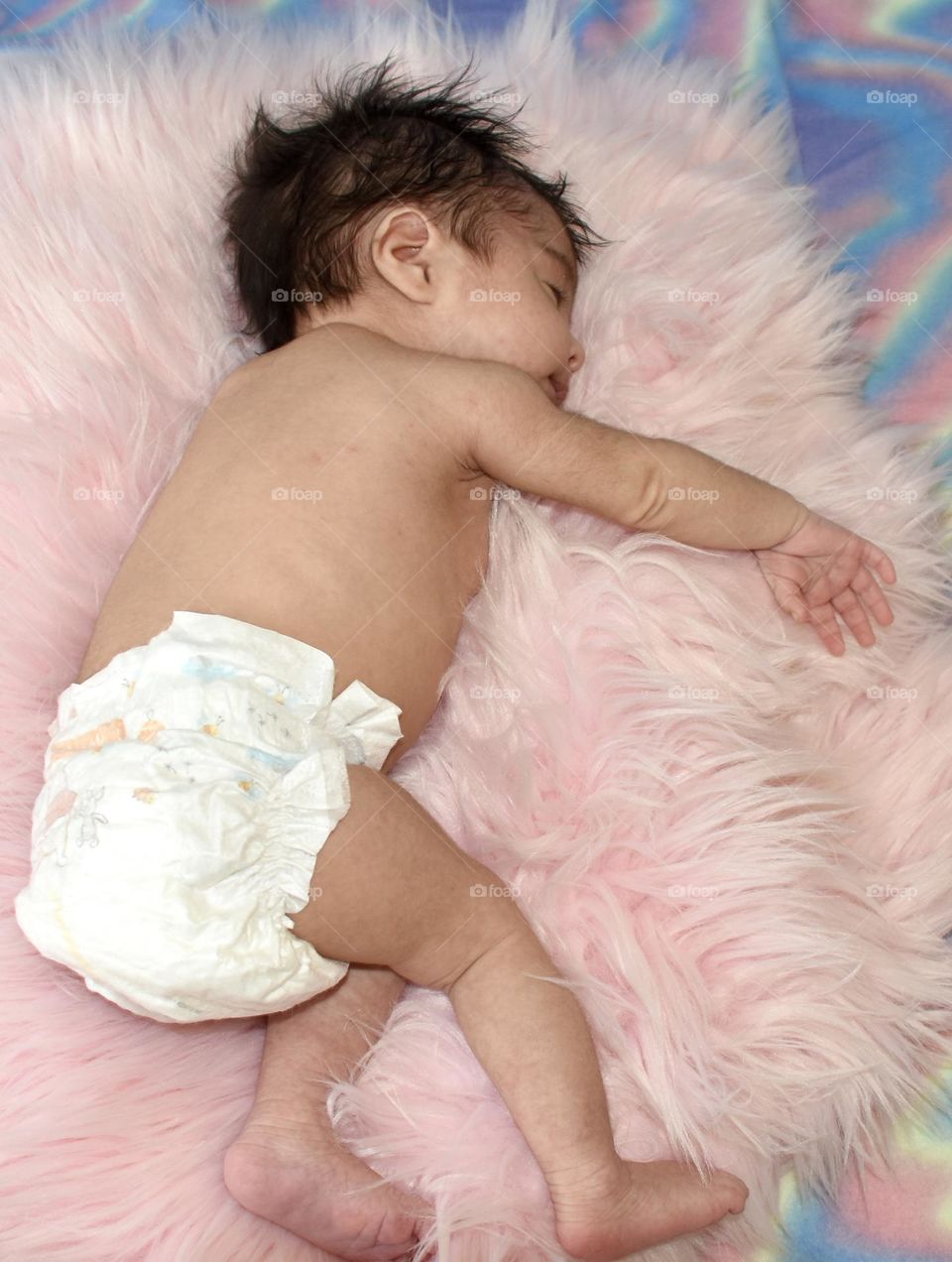 Baby resting on pink fluffy rug 