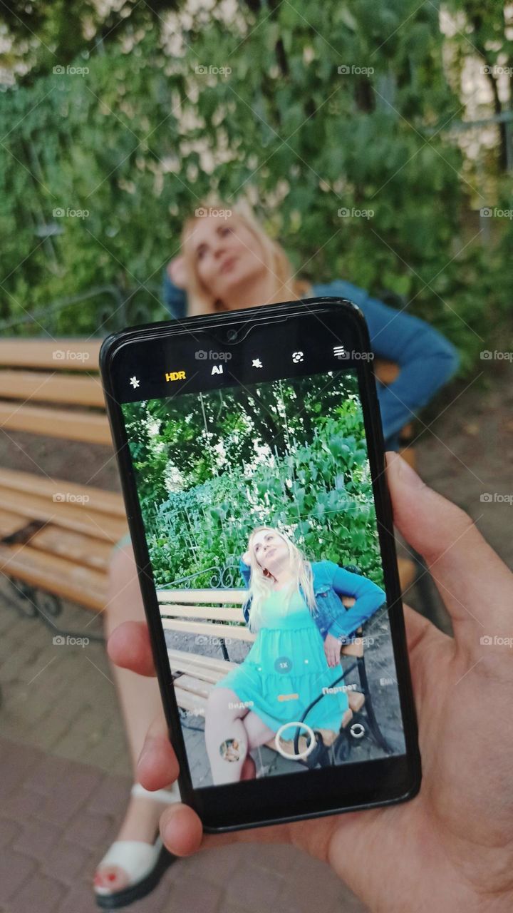 guy takes a picture of a girl on a mobile phone