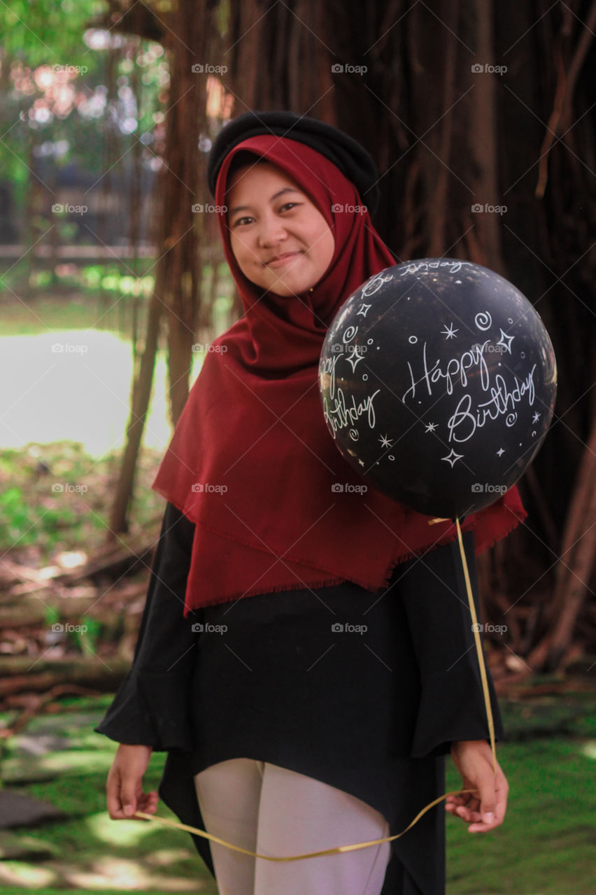 a beautiful girl with a black balloon