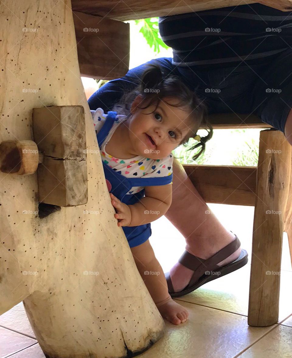 Girl under the table at grandfather’s feet