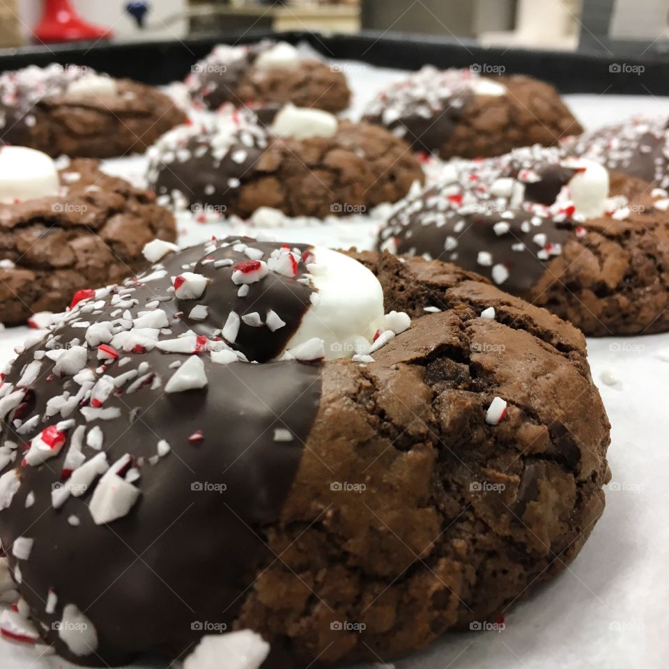 Hot chocolate cookies! Chocolate, chocolate chip cookies with a marshmallow squished in, dipped in chocolate and topped with crushed candy canes!