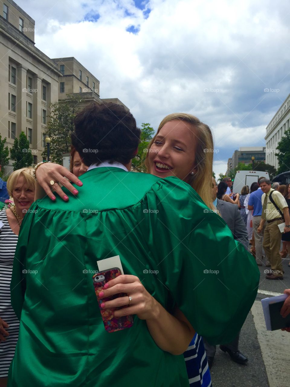 Happy young woman hugging graduated man