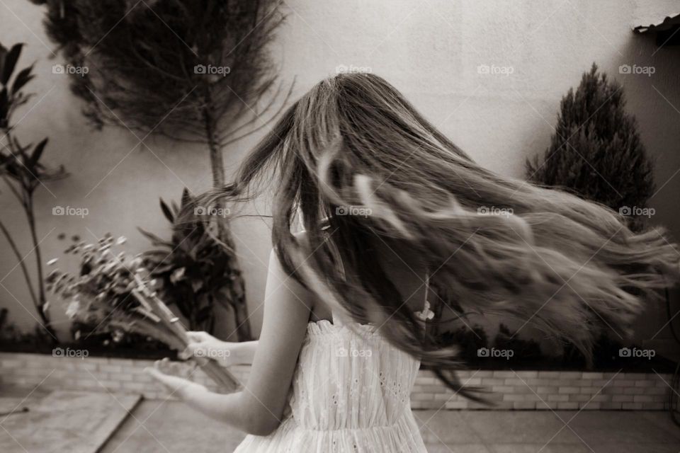 Girl dancing with a bouquet of flowers in her hands.