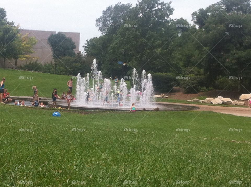 Kids Playing in the Fointains. Kids playing in a fountain, on a hot summer day in a park.