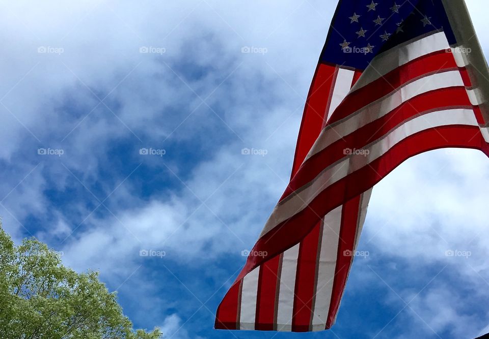 American Flag🇺🇸blowing against blue sky!