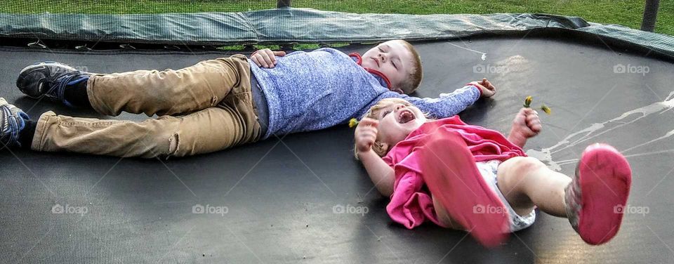 My kids are taking a break after jumping on the trampoline.