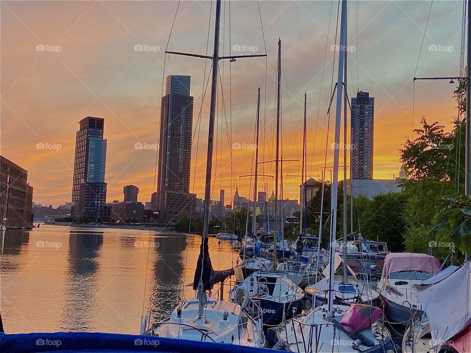 Another view of the “East River” at “Newtown Creek” by the “Pulaski Bridge” in LIC, Queens, NY at sunset time. The fiery orange red tones in the sky are offset against the silvery streaks of the clouds. 2022. Hypnotic Productions