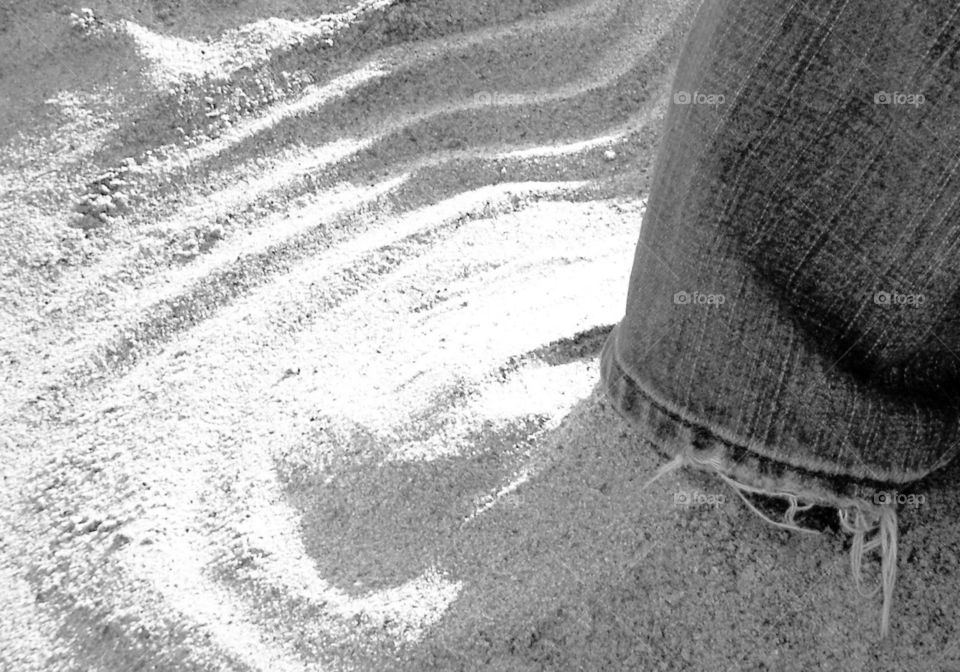 Black and white foot buried in sand