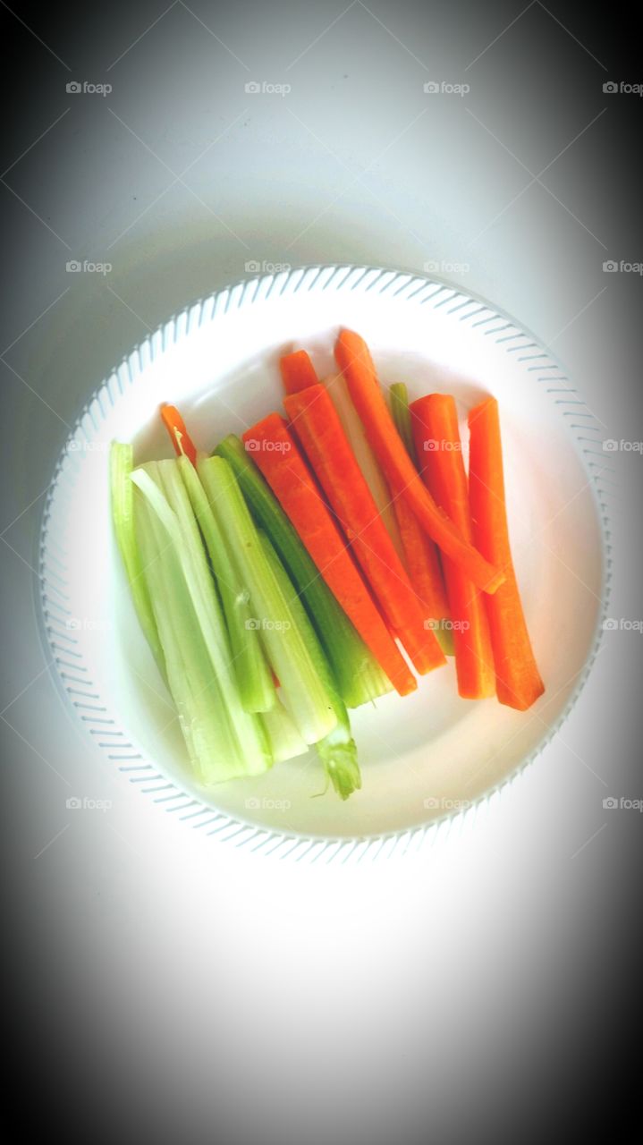 Carrots & Celery . carrots  and celery in a white  plate on the white  surface 