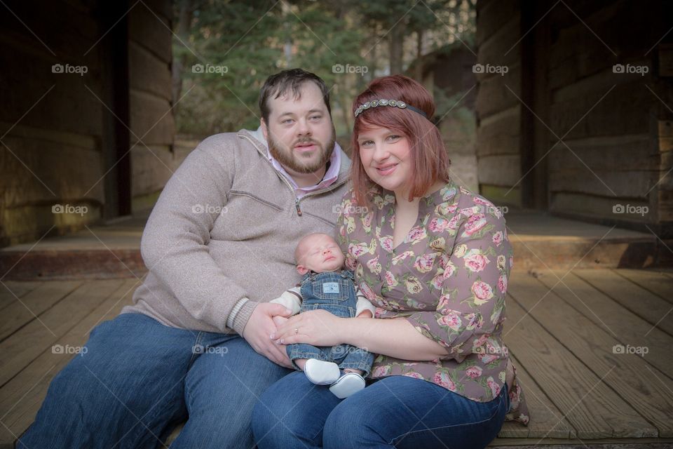 Husband and wife sitting and holding newborn baby