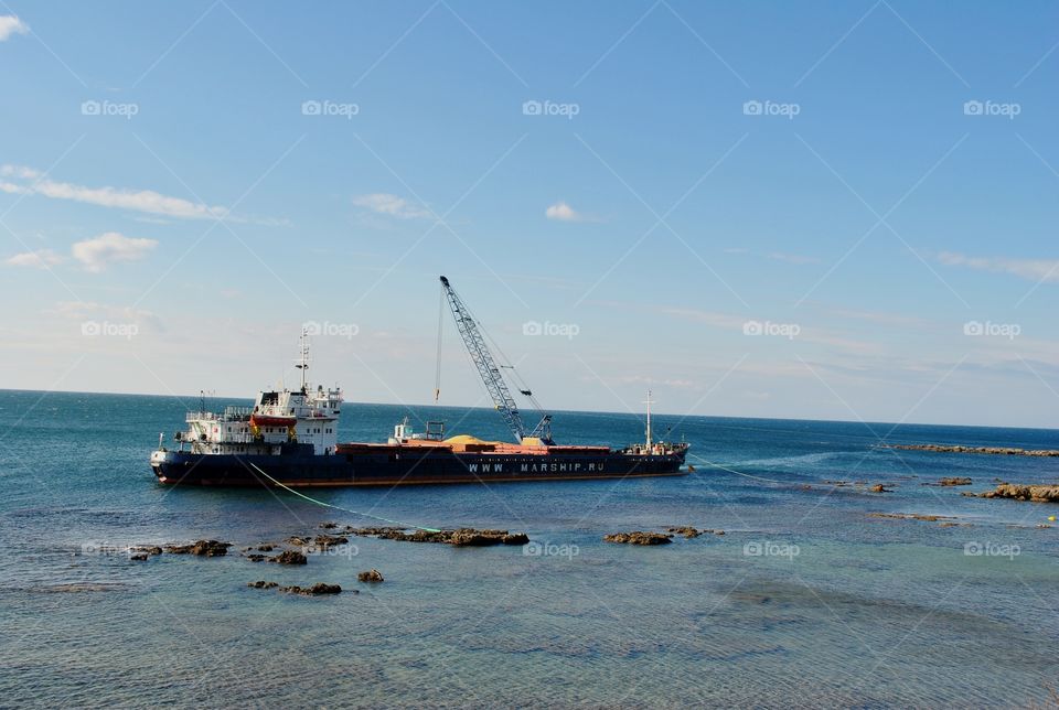 cargo ship parking beside rocks