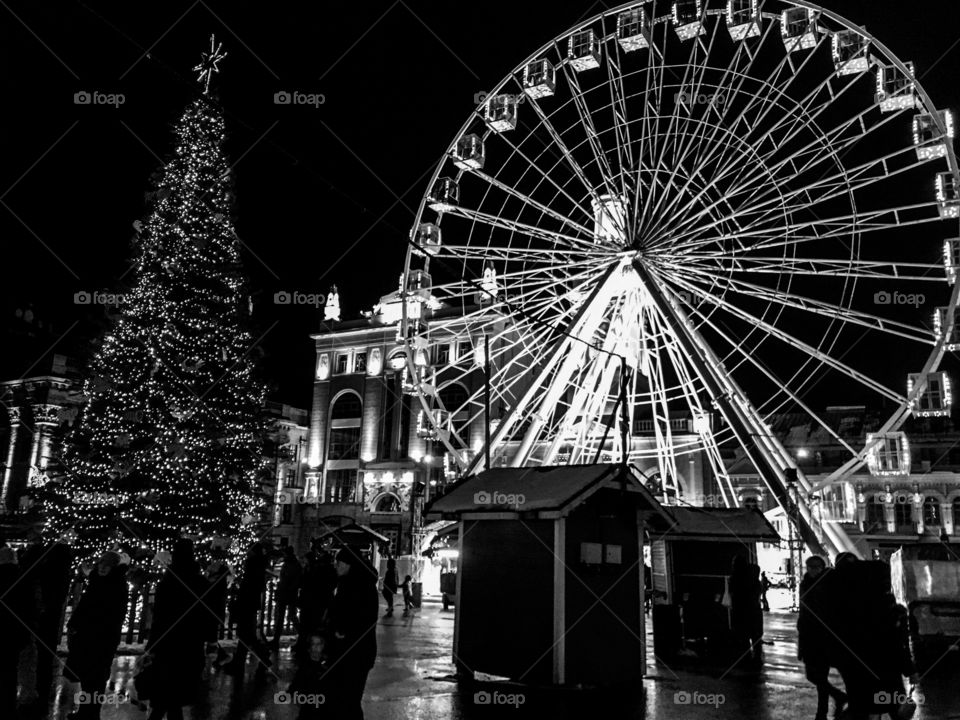 The black and white picture of new year fair in Kiev, Ukraine. Christmas fair in historical part of city. Ferris wheel. Festival time. 
