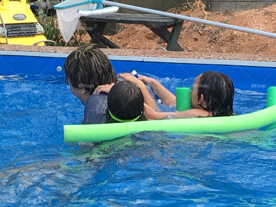 Swimming pool antics. Fun in the swimming pool in Australia. Teen and children playing