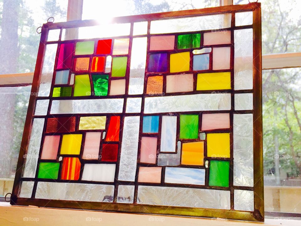 Colorful Stained Glass Window with Sunshine glowing through Window.  