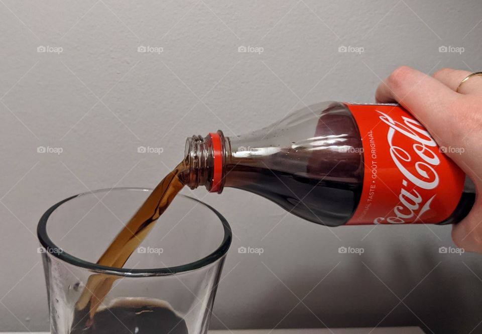 pouring a glass of Coca-Cola