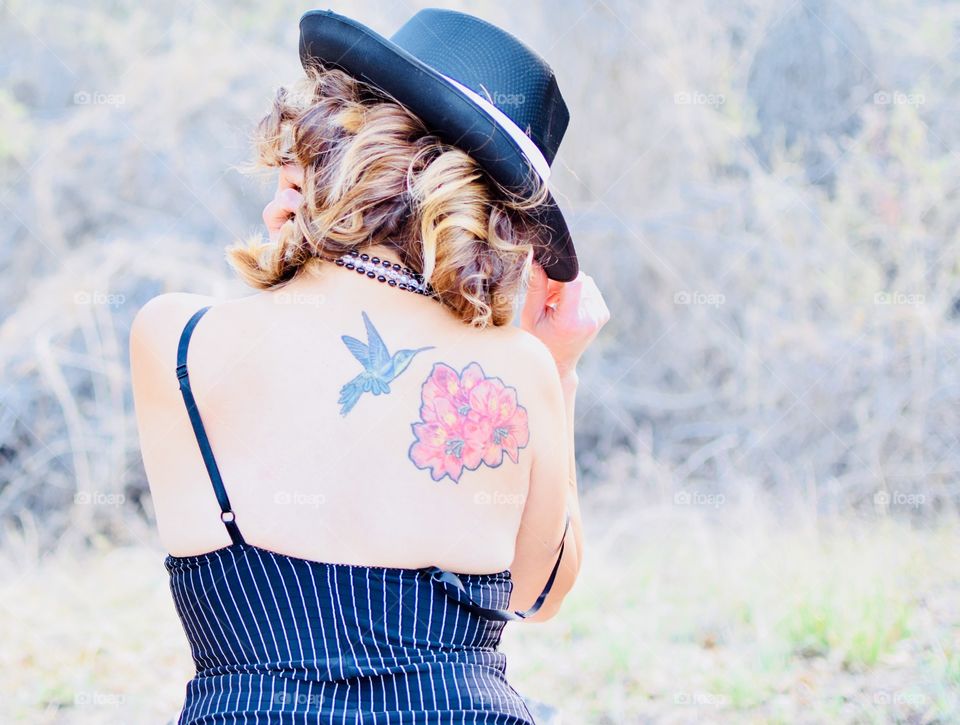 A Lady in Lingerie with a back tattoo 